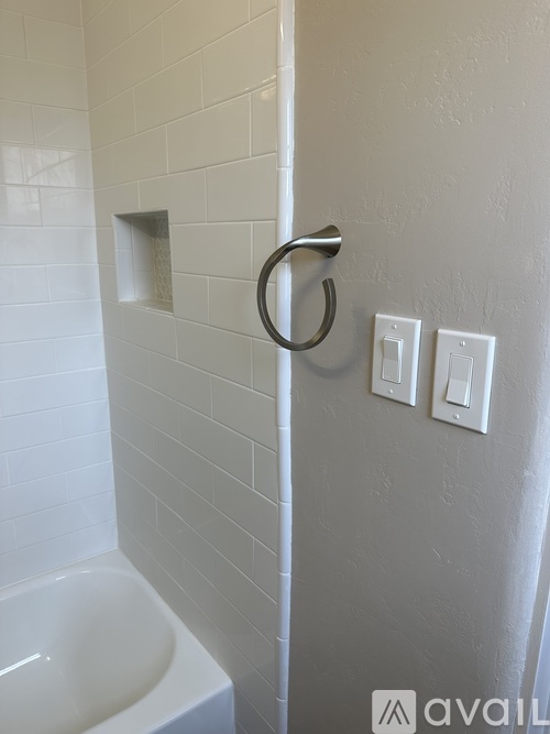 A bathroom with a white tub and a towel rack.