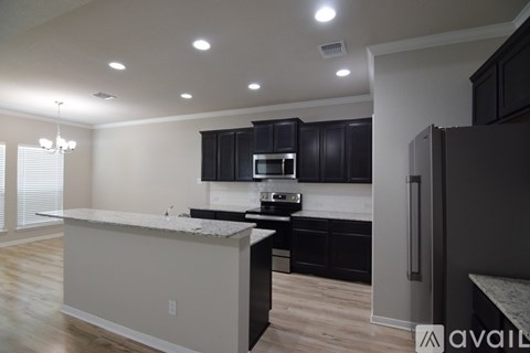 A modern kitchen with dark wood cabinets and a white island.