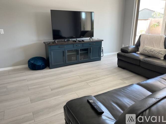 A living room with a television, a couch, and a remote control.
