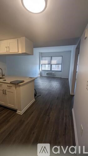 A kitchen with white cabinets and a wooden floor.