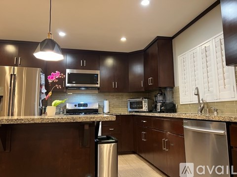 A kitchen with brown cabinets and a granite countertop.
