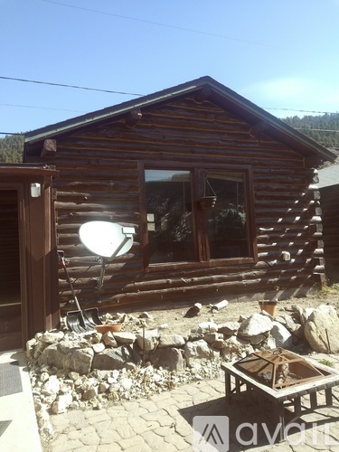 A wooden house with a satellite dish on the roof.
