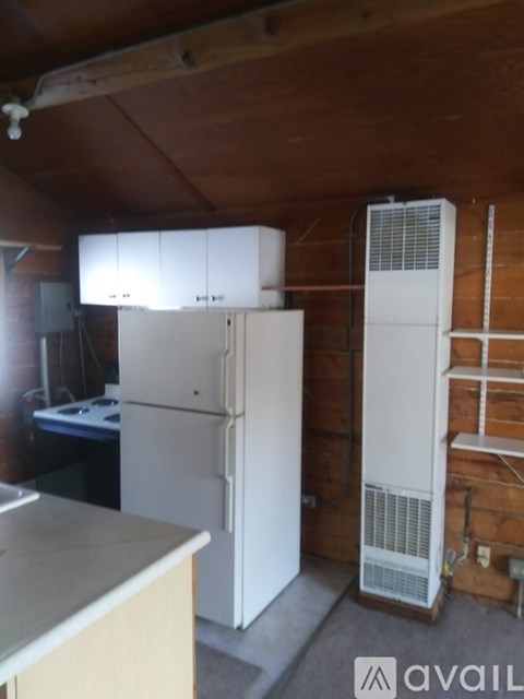 A kitchen with a white fridge and cabinets.