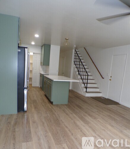 A kitchen with a refrigerator and a staircase.