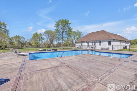 A large swimming pool with a house in the background.