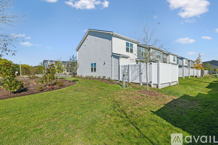 A row of houses with a grassy area in front.