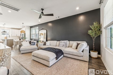 A living room with a large sectional sofa and a rug.