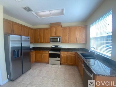 A kitchen with wooden cabinets and a black countertop.