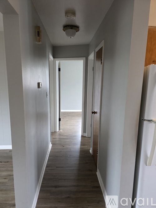 A long hallway with a white door at the end.