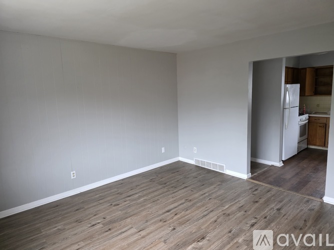 A room with wooden flooring and white walls.