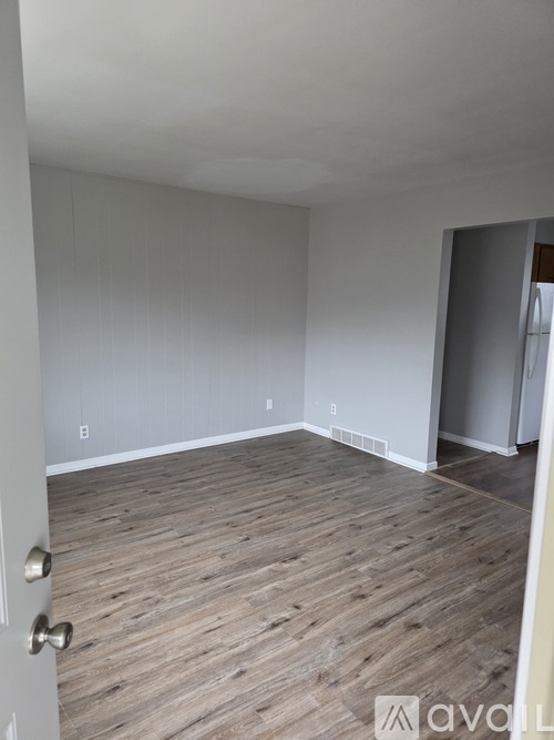 A room with wooden flooring and a white door.