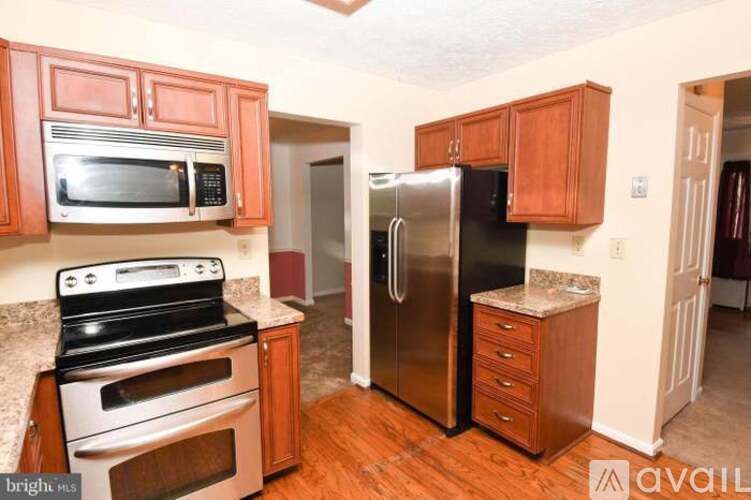 A kitchen with wooden cabinets and a stainless steel refrigerator.