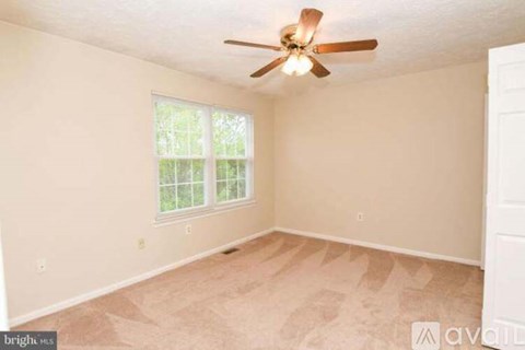 A room with a ceiling fan and a window.