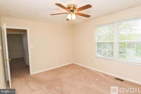 A room with a ceiling fan and a window.