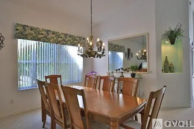 A dining room with a wooden table and chairs.