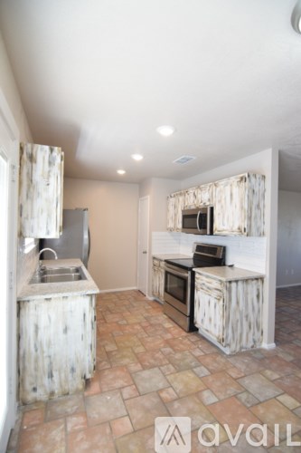 A kitchen with a sink and a stove top oven.