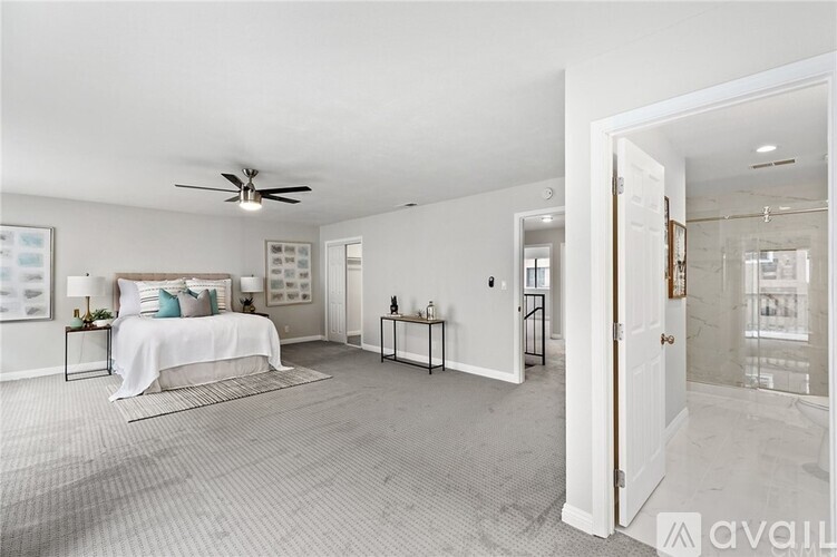 A spacious bedroom with a large bed and a ceiling fan.