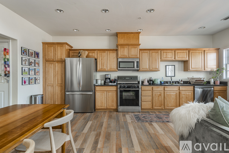 A kitchen with wooden cabinets and a wooden table.
