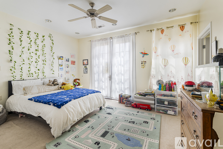 A bedroom with a white bed and a blue blanket.