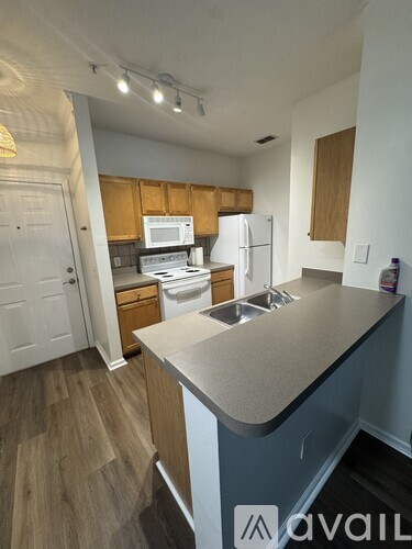 A kitchen with a white refrigerator and wooden cabinets.