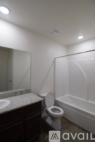 A spacious room with a ceiling fan and two windows.
