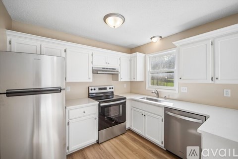 A kitchen with white cabinets and stainless steel appliances.