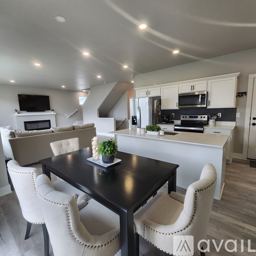 A modern kitchen with a dining table and chairs.
