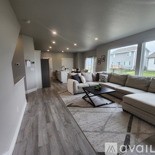 A spacious living room with a grey floor and white furniture.