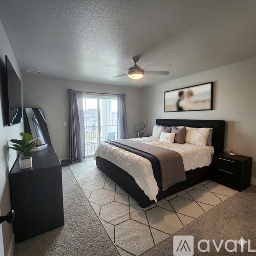 A bedroom with a large bed and a ceiling fan.