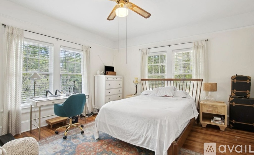 A bedroom with a bed, desk, and chair.