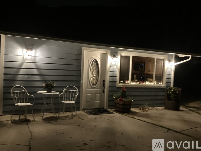 A small table with two chairs is set up outside a house.