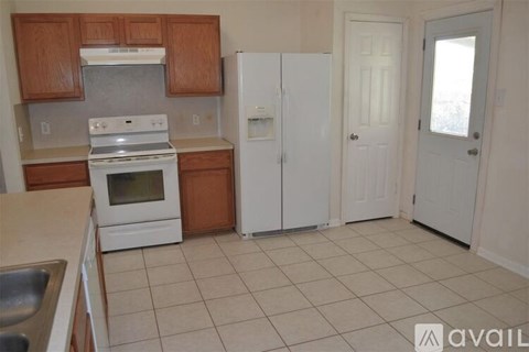 A kitchen with a white stove and a white refrigerator.