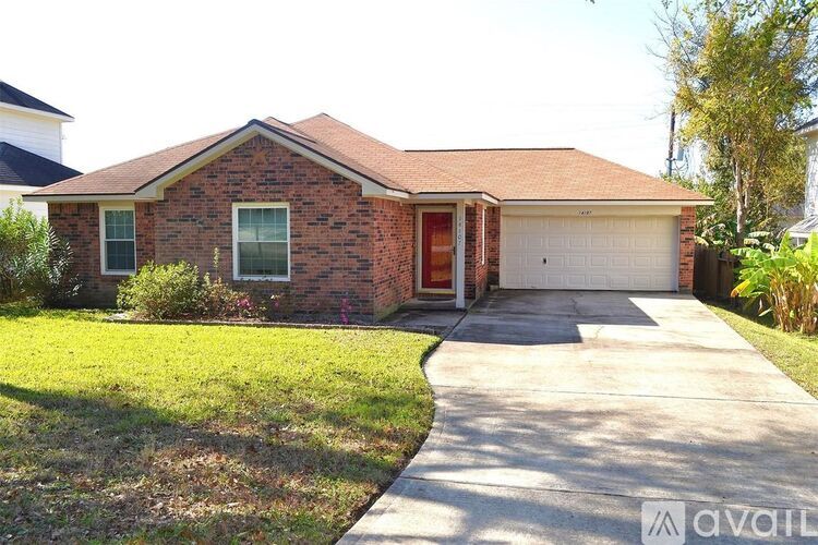 A brick house with a red door and a garage.
