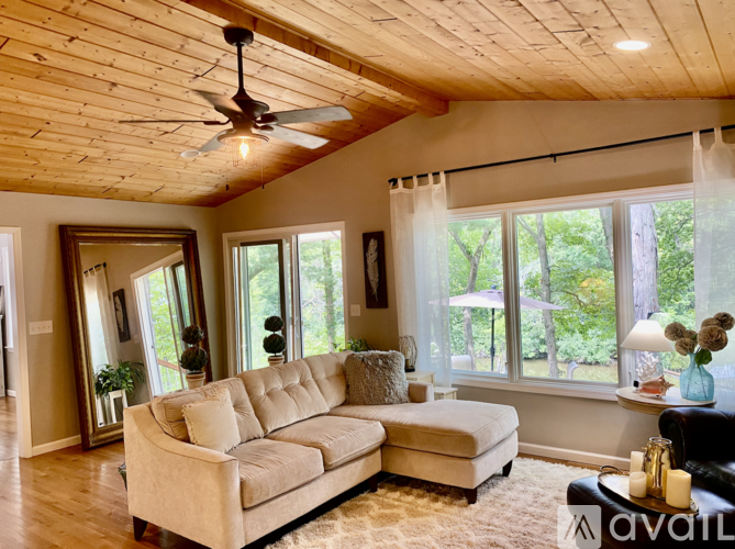 A living room with a beige sofa and a ceiling fan.