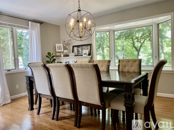 A dining room with a table and chairs.