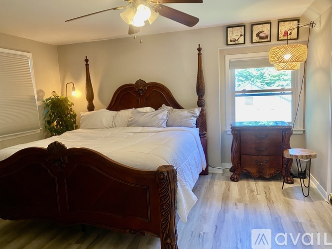 A bedroom with a large bed and a window with a view.