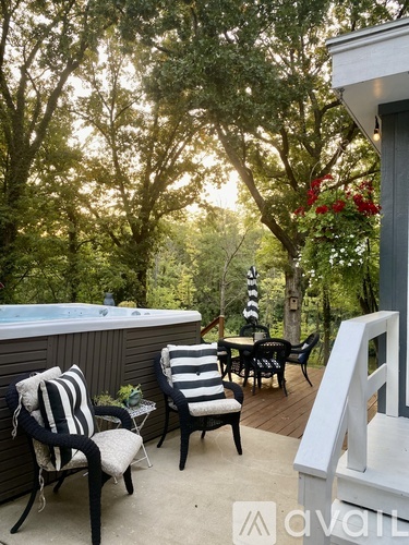 A patio with striped chairs and a hot tub.