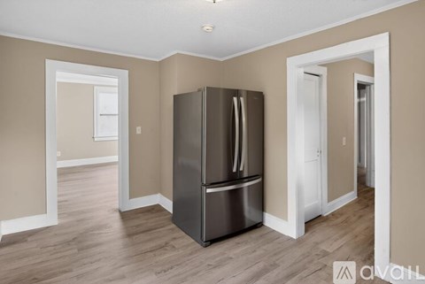 A kitchen with a stainless steel refrigerator in the middle of the room.