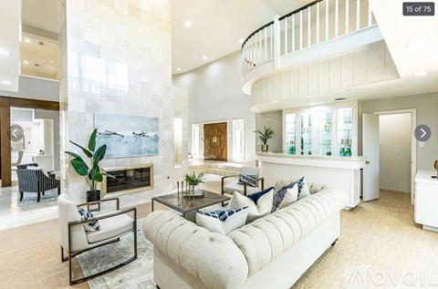 A modern living room with a white sofa and a glass coffee table.