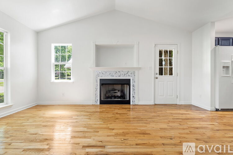A living room with a fireplace and hardwood floors.