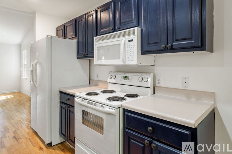 A kitchen with a white stove top oven and a white microwave above it.