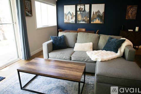 A living room with a grey couch and a wooden coffee table.