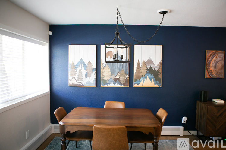 A dining room with a wooden table and chairs.