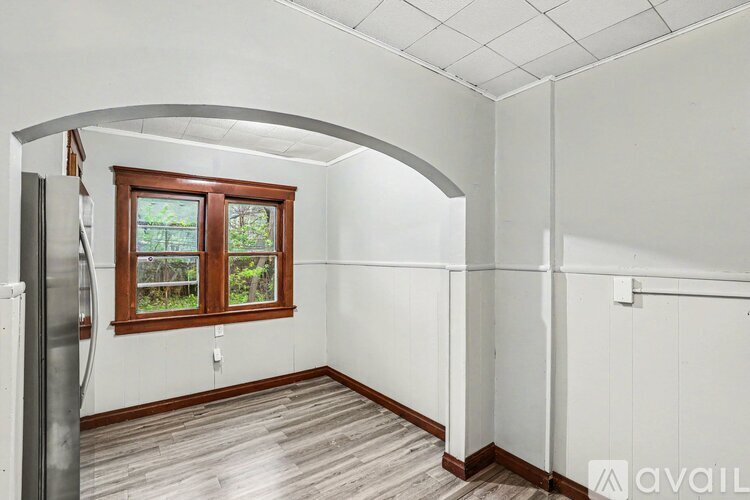 A room with a window and a white wall.