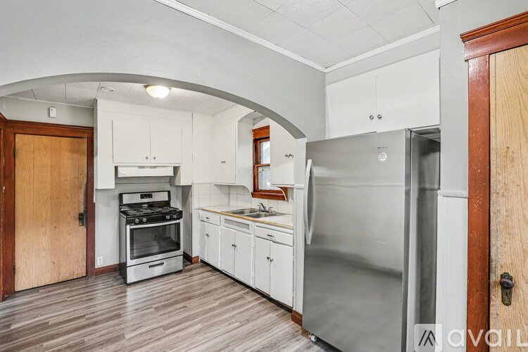 A kitchen with a refrigerator, oven, and cabinets.
