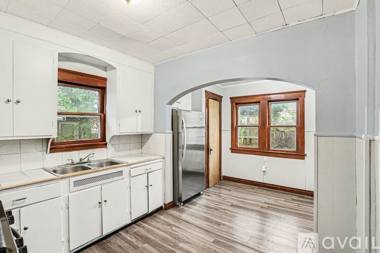 A kitchen with white cabinets and a wooden floor.