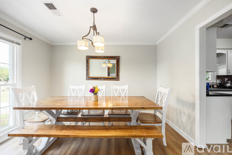 A dining room with a wooden table and chairs.