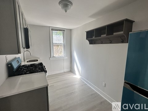 A kitchen with a stove top oven and a window.