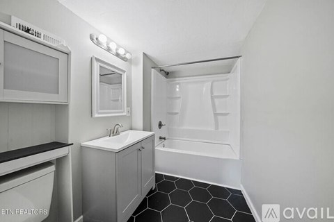 A bathroom with a sink, mirror, and toilet.
