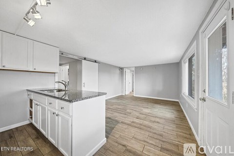A kitchen with white cabinets and a granite countertop.